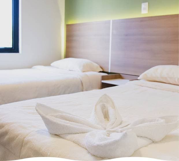 Cama decorada con corazón de pétalos de rosa y listones